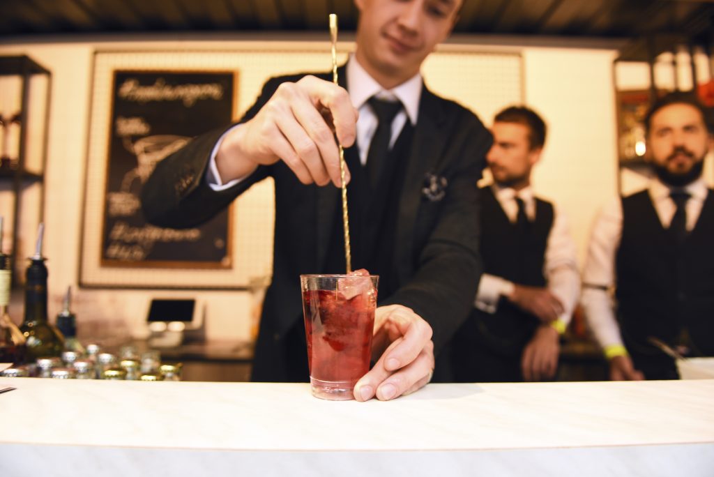 A mixologist serves a cocktail.
