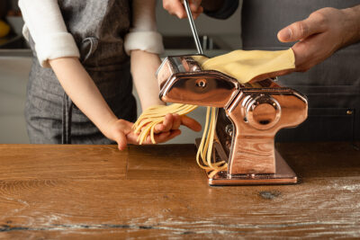 Hands working a pasta making device
