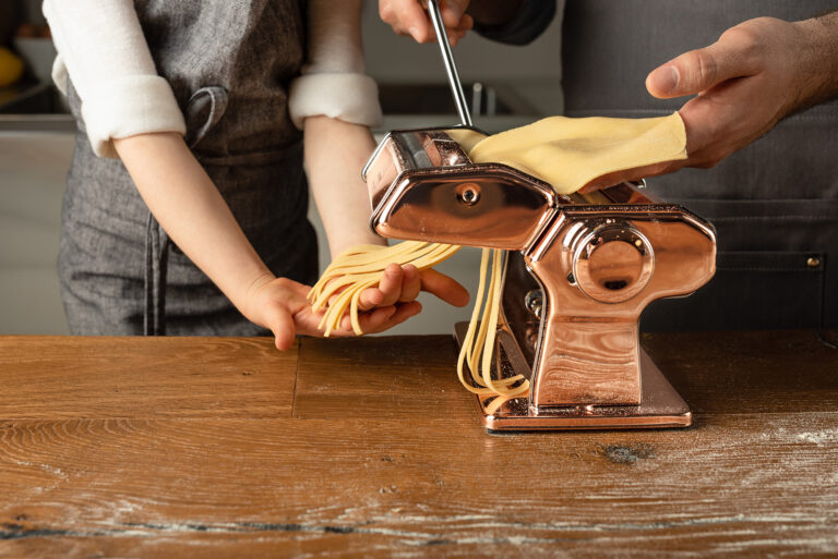 Hands working a pasta making device
