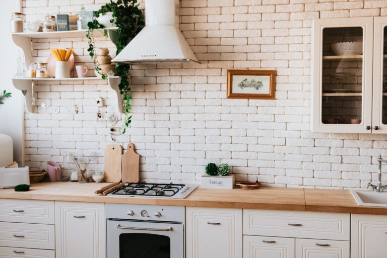 A white and beige kitchen with wood worktops.