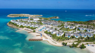 A beautiful aerial view of Hammock Cove Antigua highlights the sandy beaches and big blue sea.