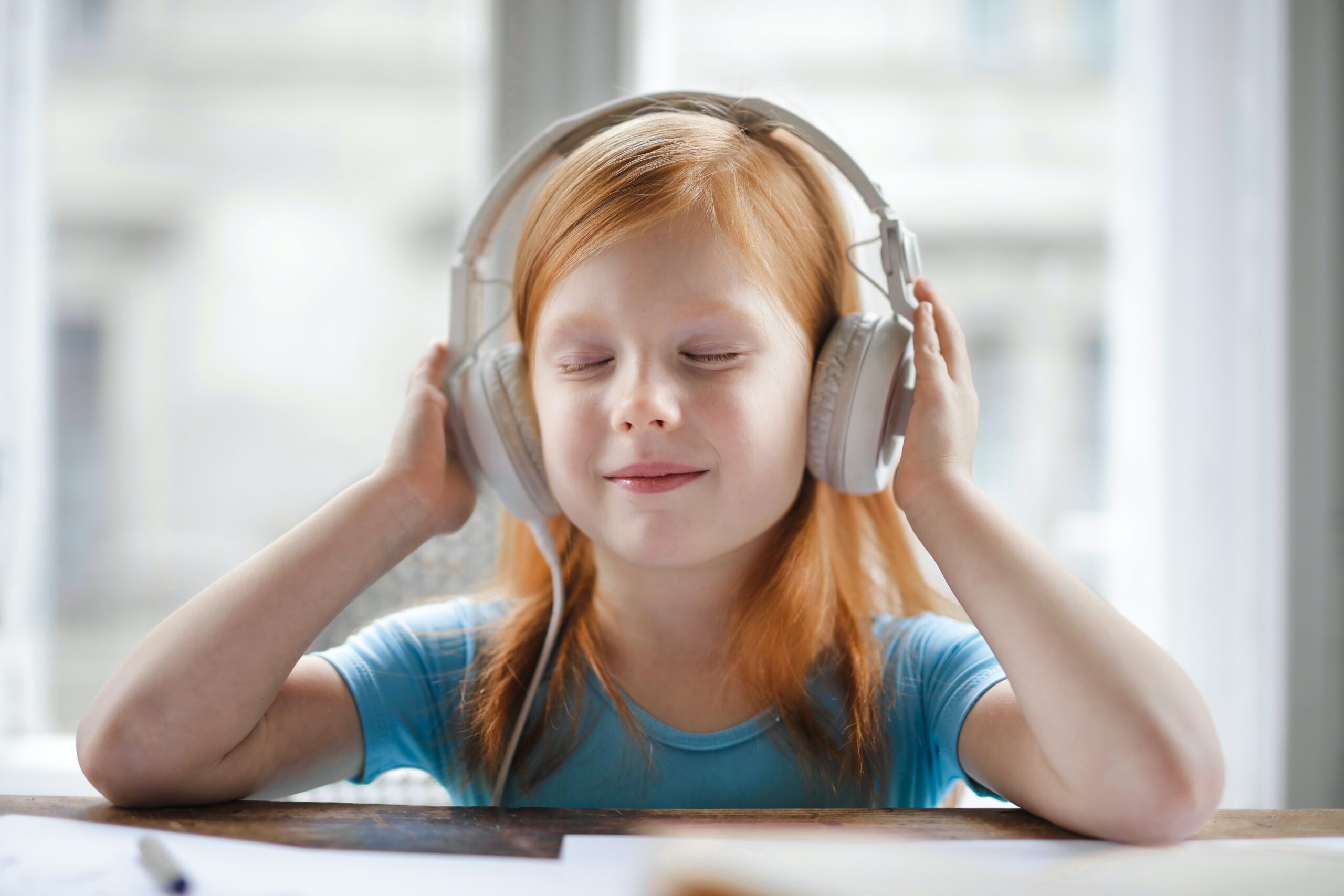 A young girl listens to music on her headphones.