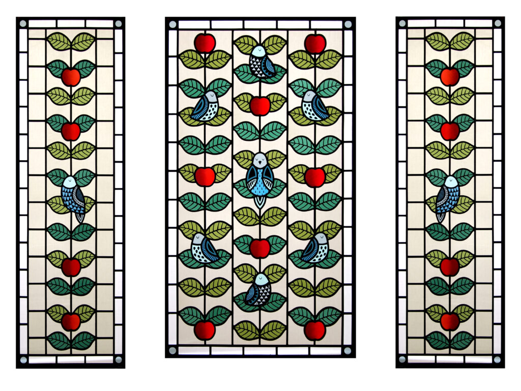 A stained glass creation of birds and apples by artist Flora Jamieson.
