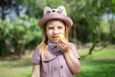 Girl in a park, holding an Easter egg