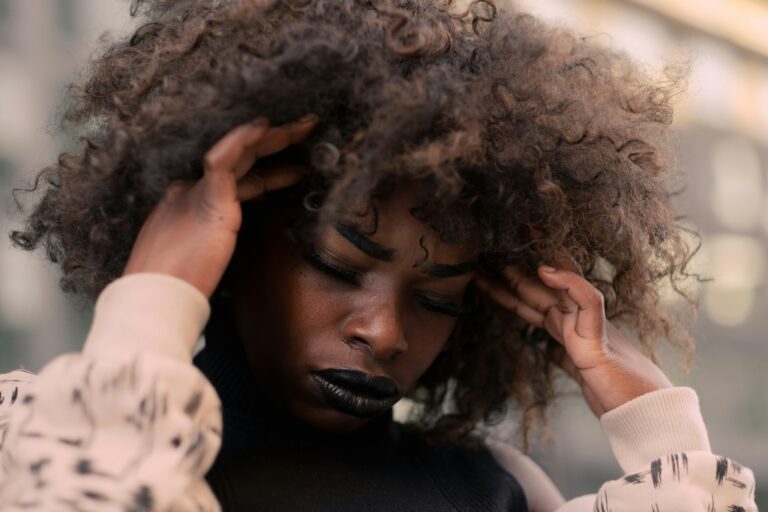A black woman looking stressed with her head in her hands
