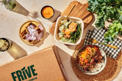 Flat lay of prepped meals in boxes with a cardboard box labelled Frive