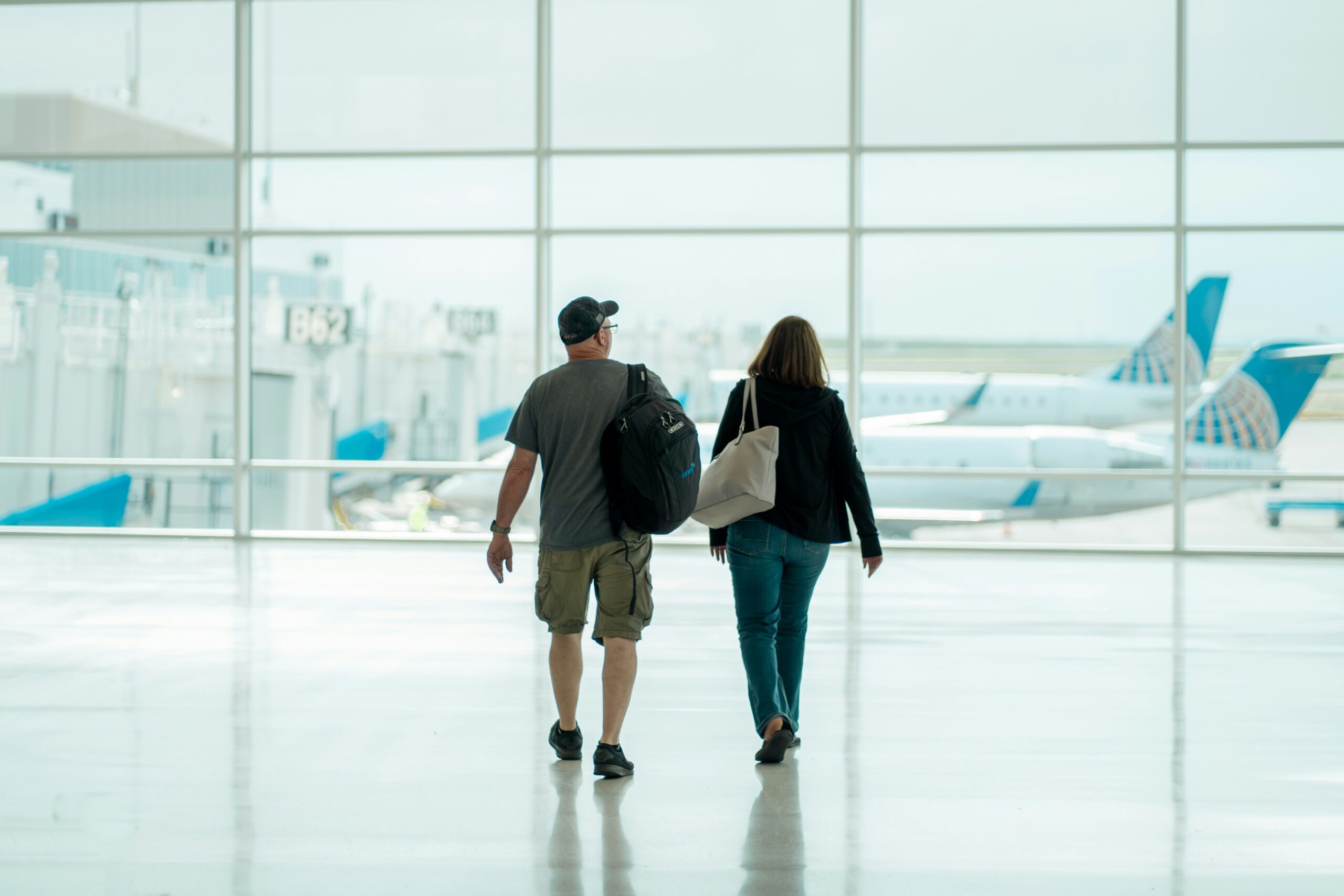 Man and woman in their 50s walk through empty airport