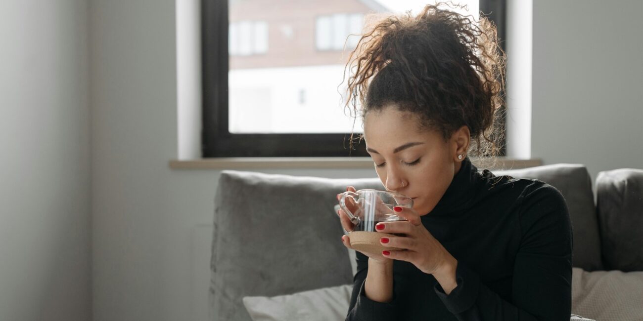 woman in bed sipping a tea with shilajit inside