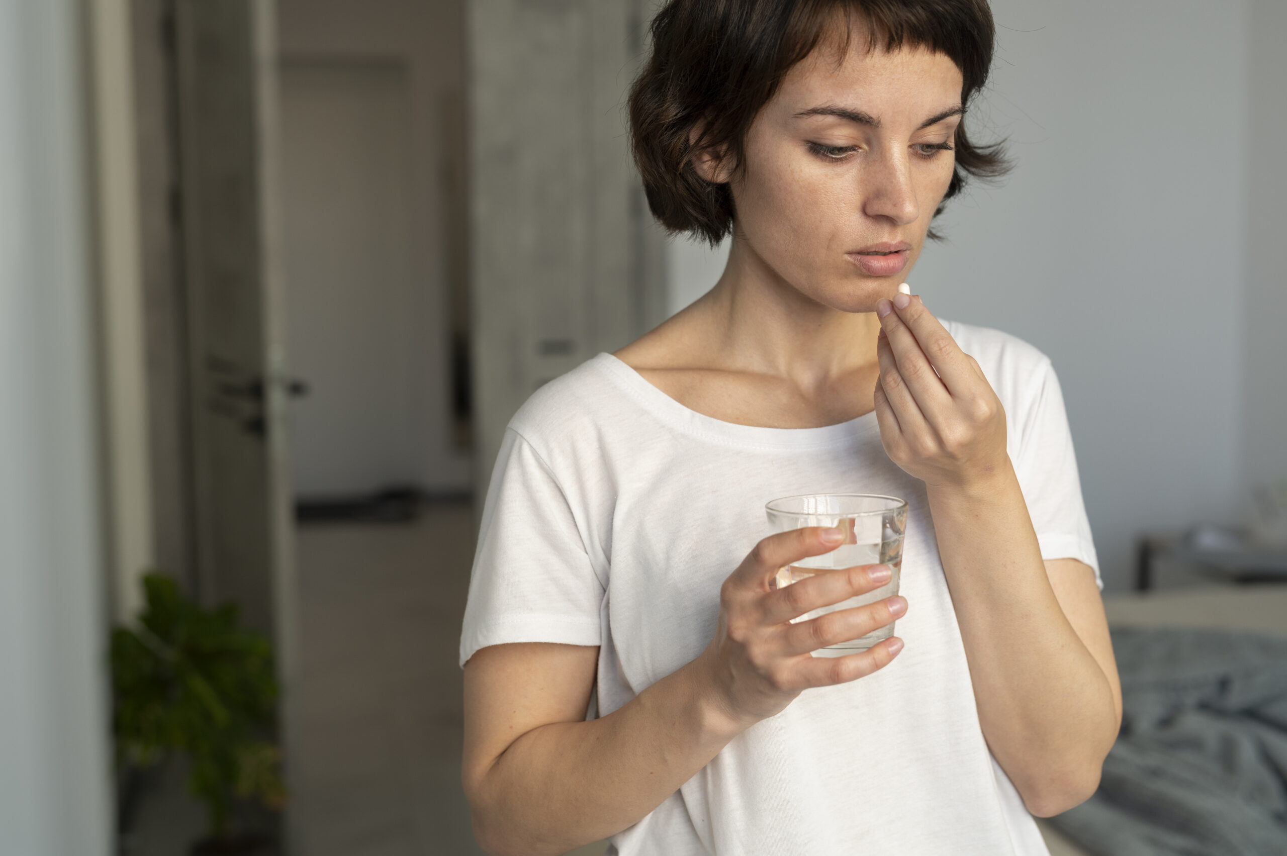 A woman takes an antidepressant ill with water 