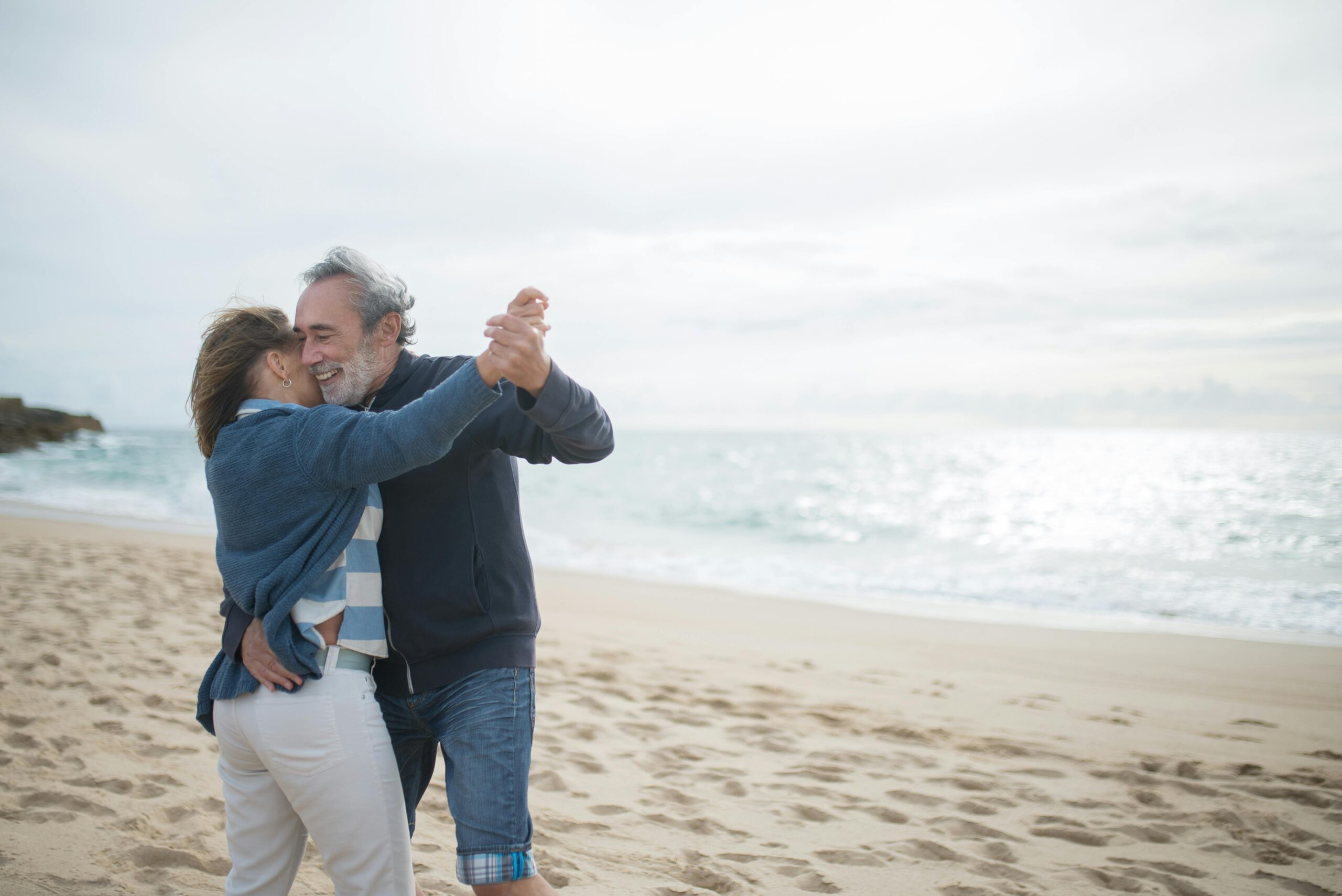 Middle aged couple dance on the beach