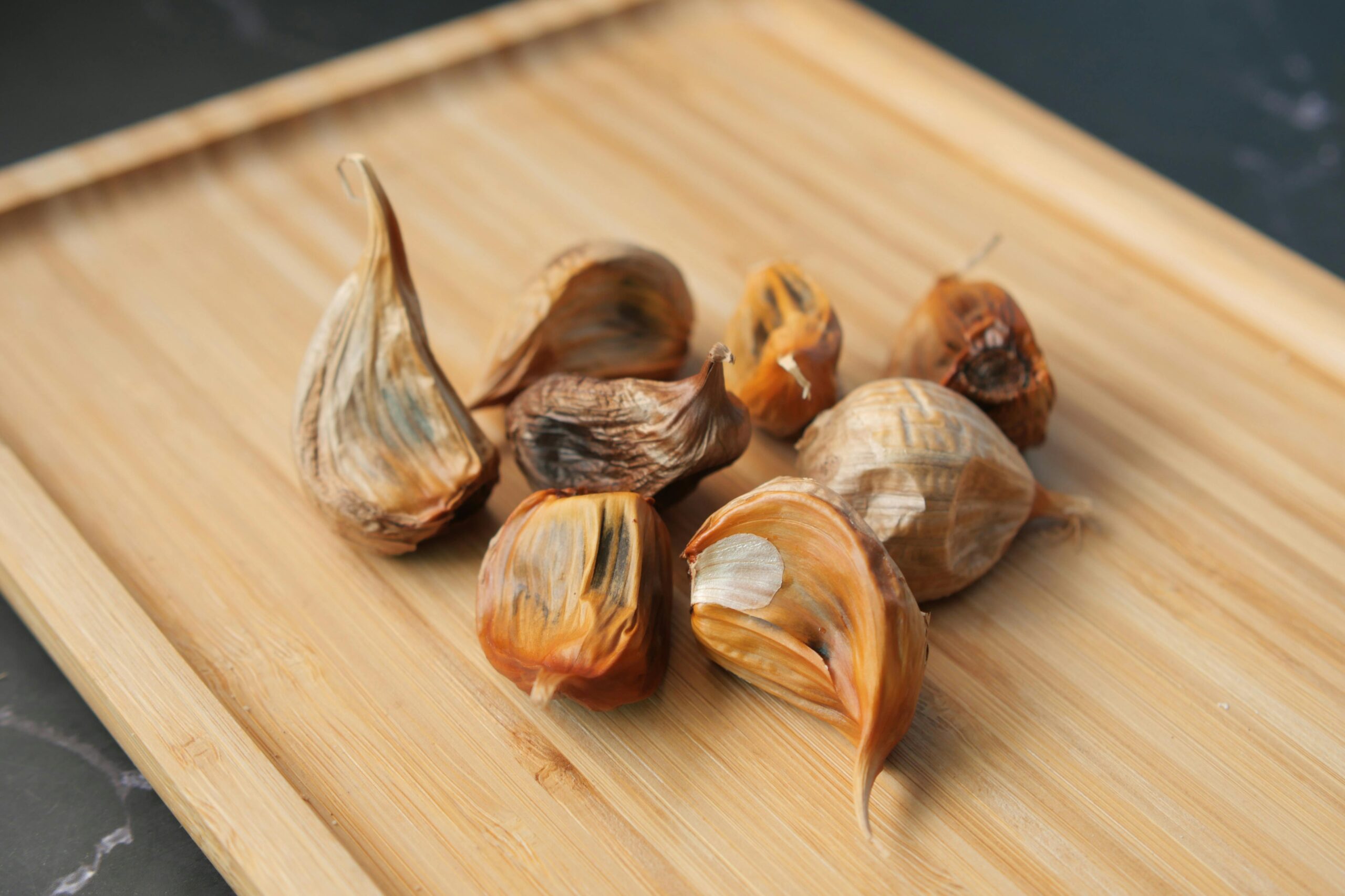 black garlic on a wooden chopping board