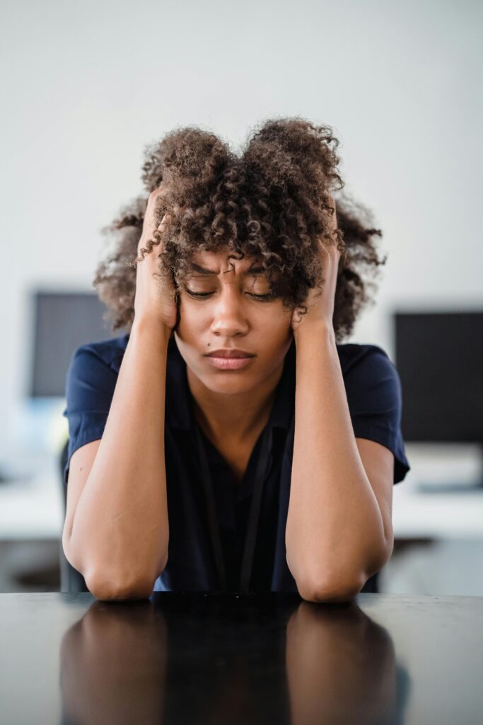 stressed woman at work holds her head