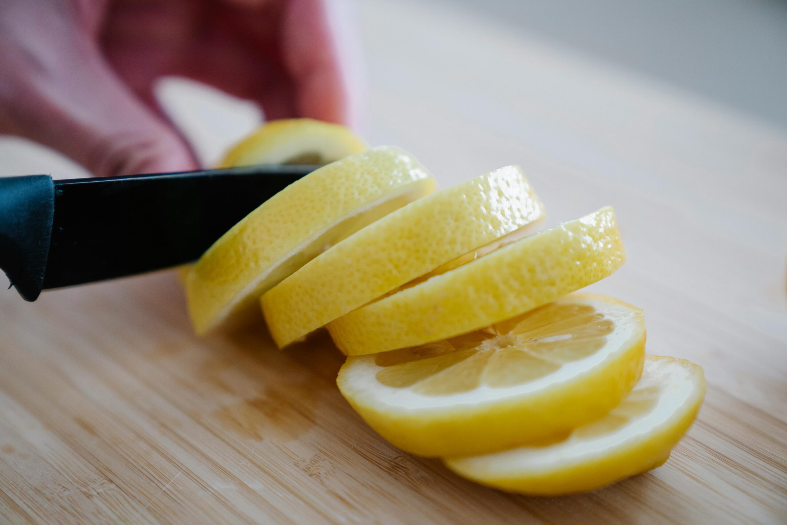 lemon being sliced into pieces with a knife