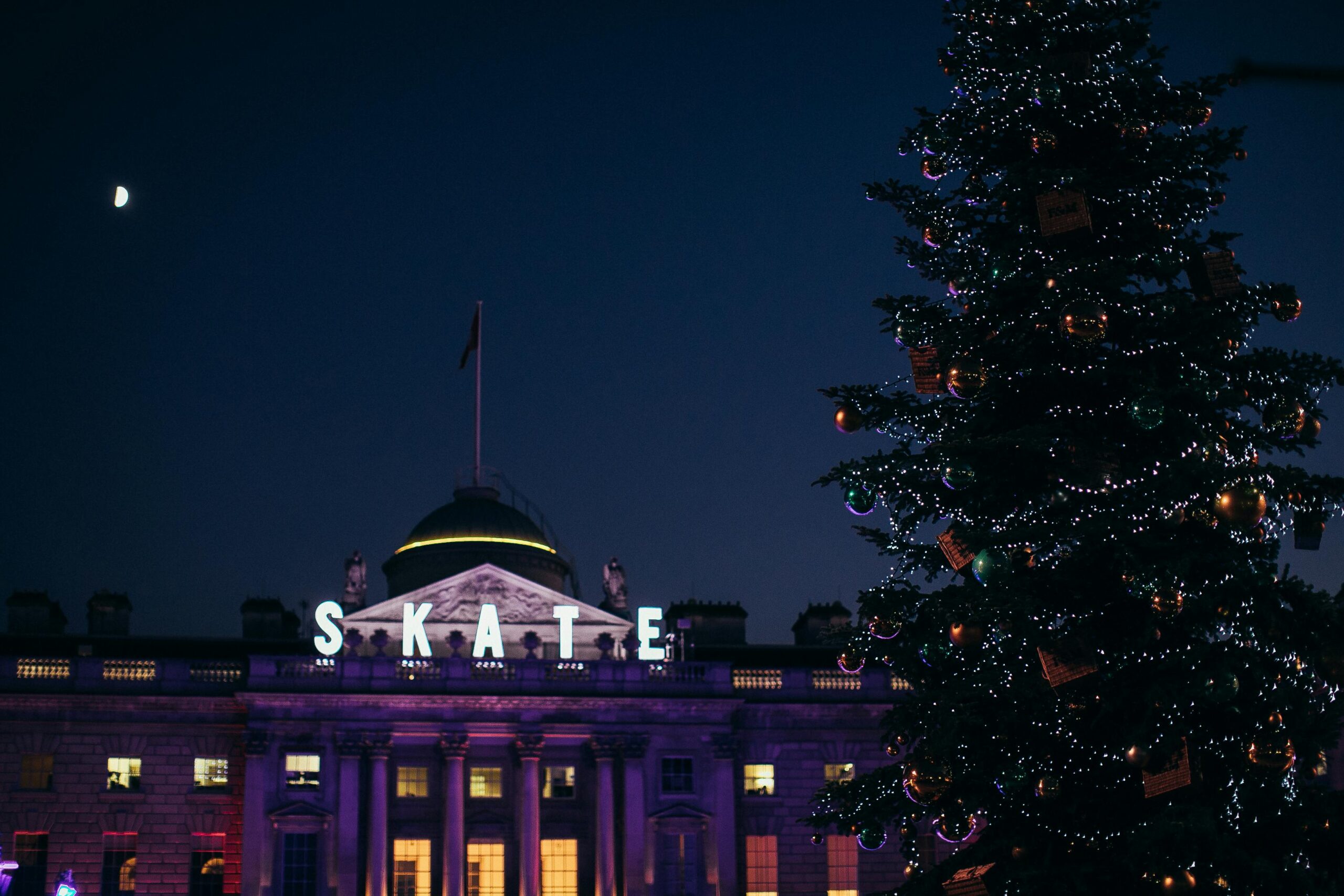 Skate sign at Skate at Somerset House courtyard lit up at night