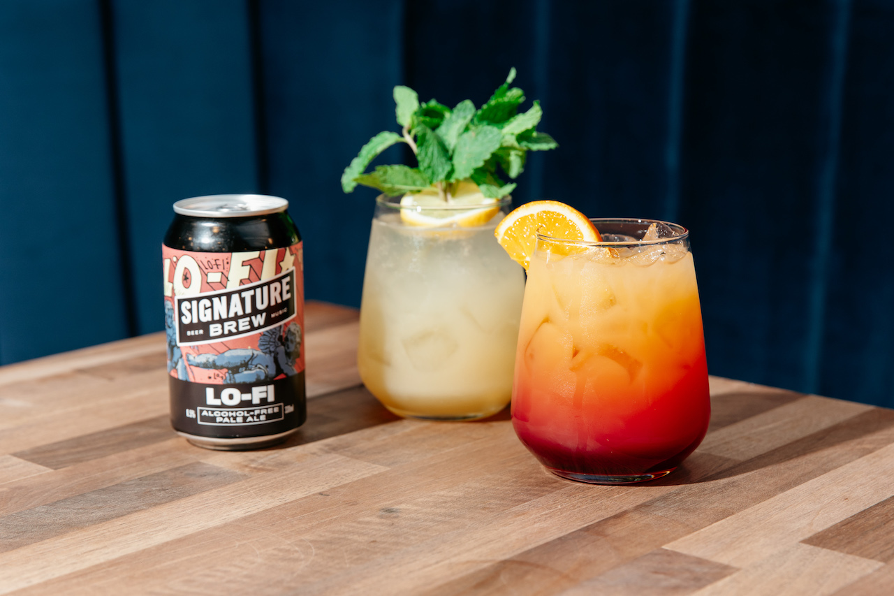 signature brew drinks can on a table and some colourful cocktails