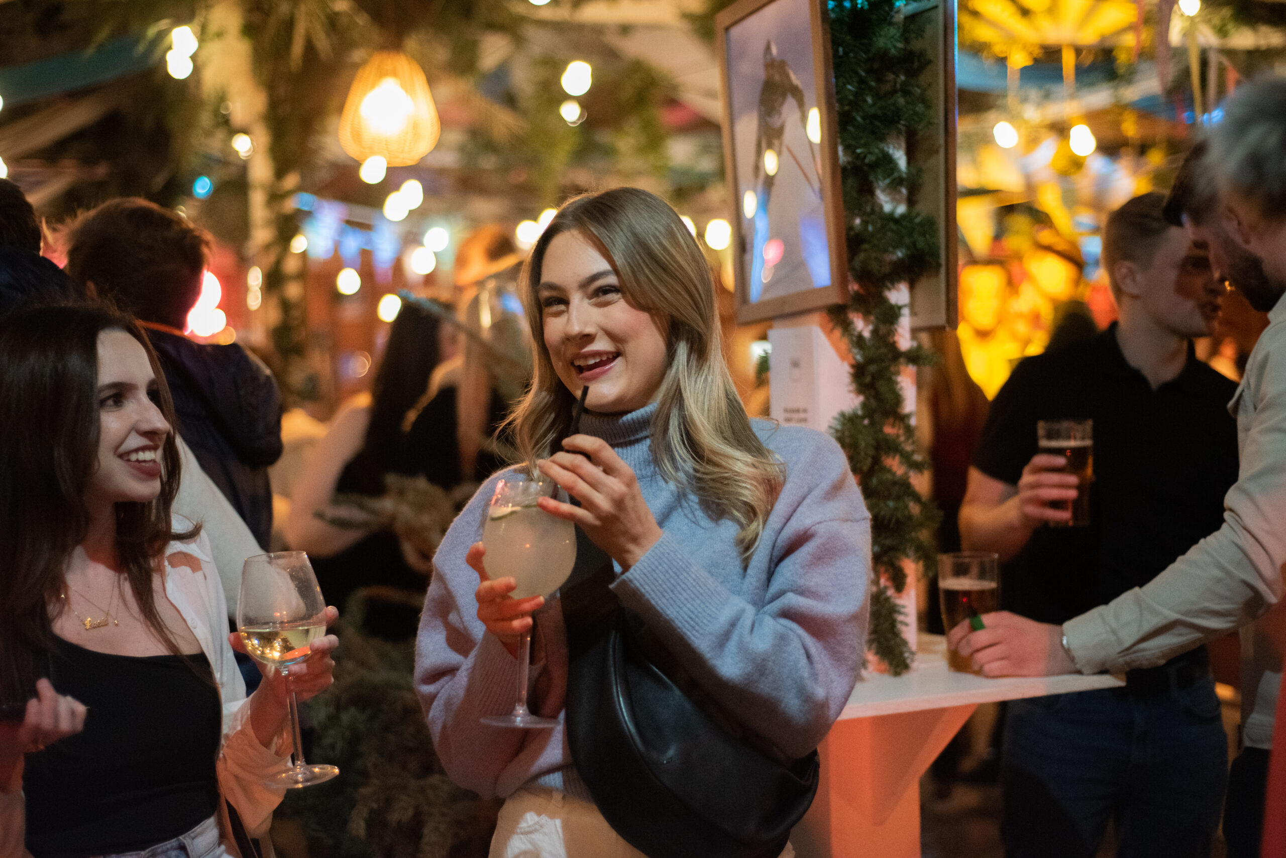 Woman sips a drink at Pergola on the Piste