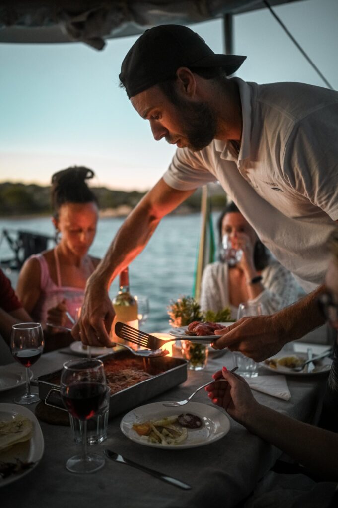 chef on a sailing boat serving up food in Corsica