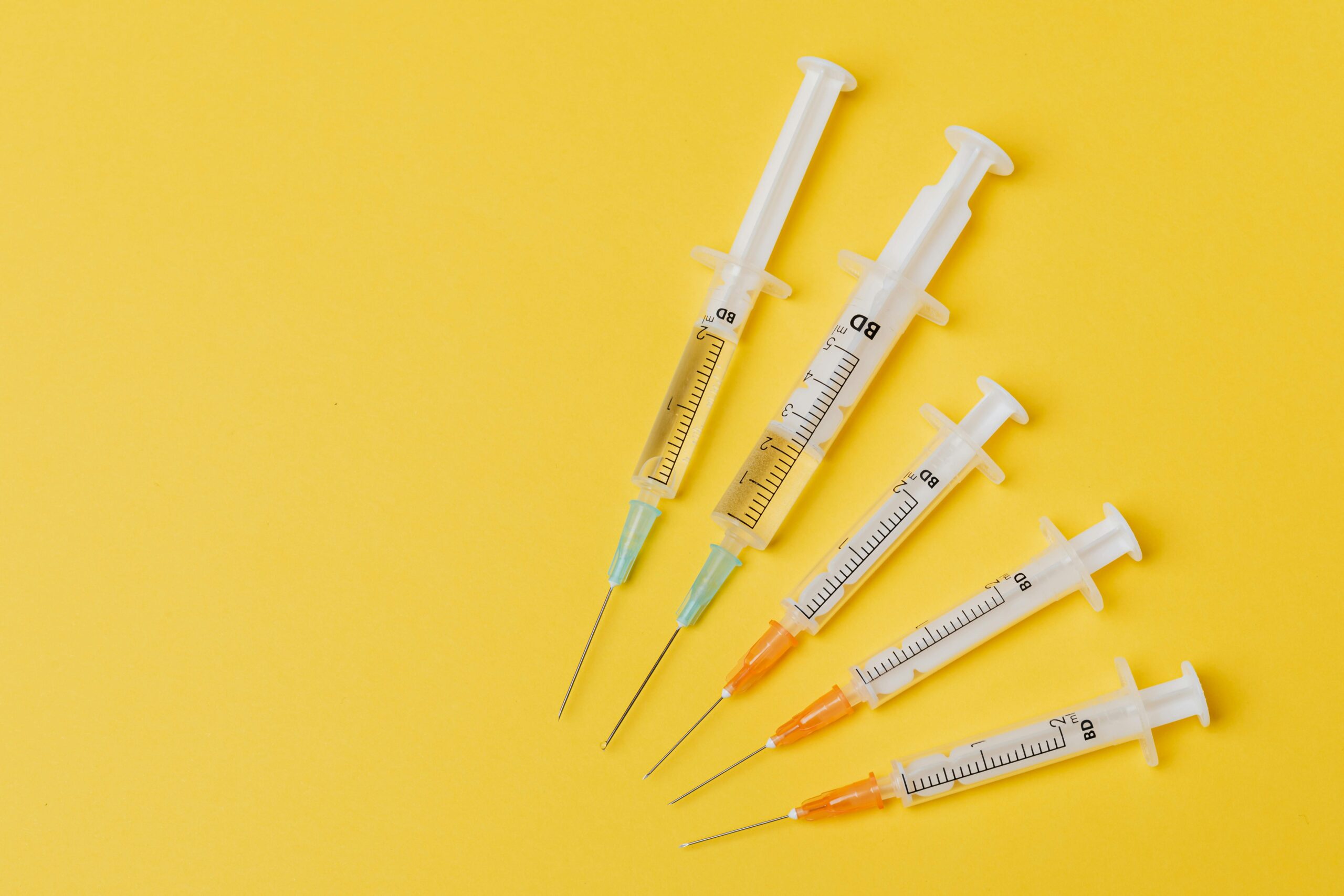 5 injection needles on a yellow background