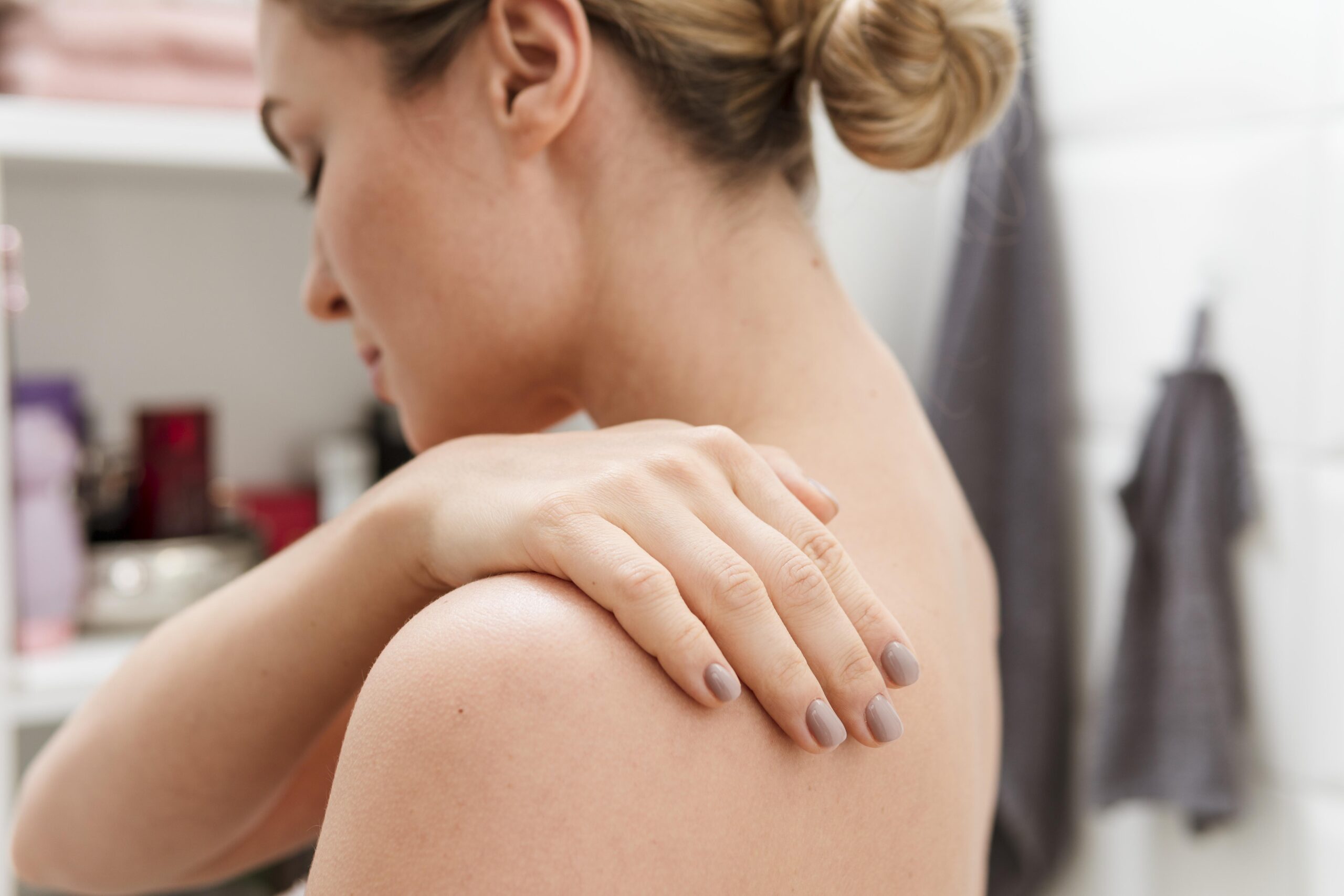 Woman massages her shoulder