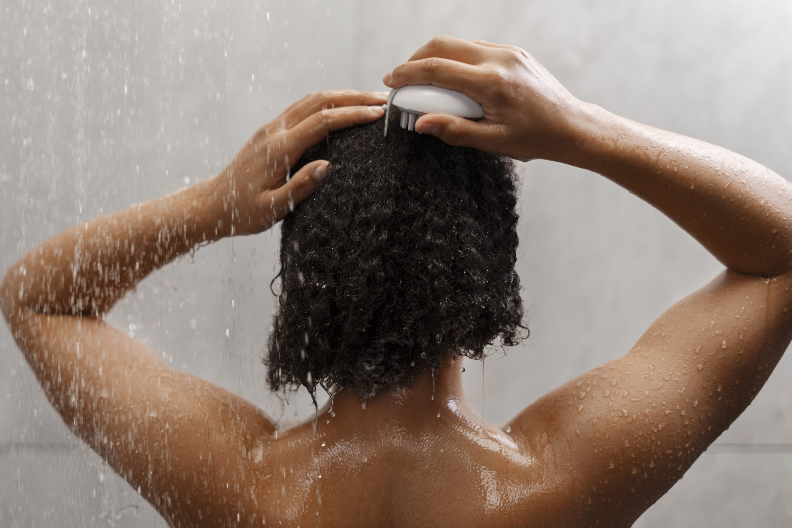 Woman with curly hair in the shower