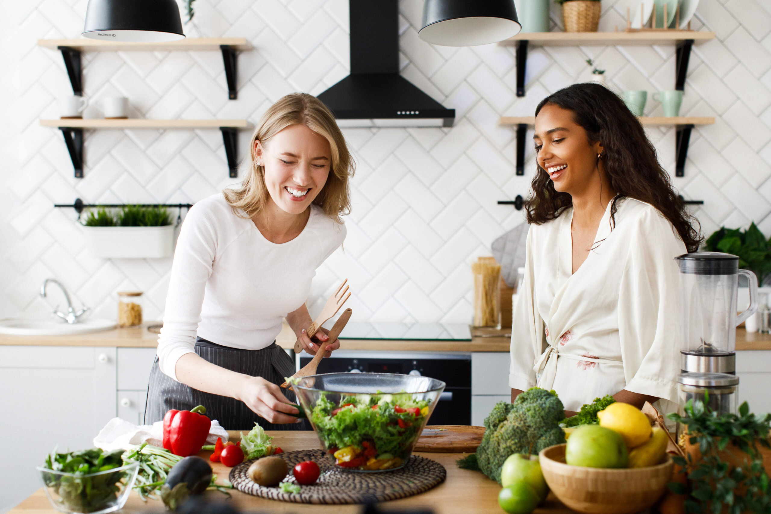 Female friends laugh while cooking