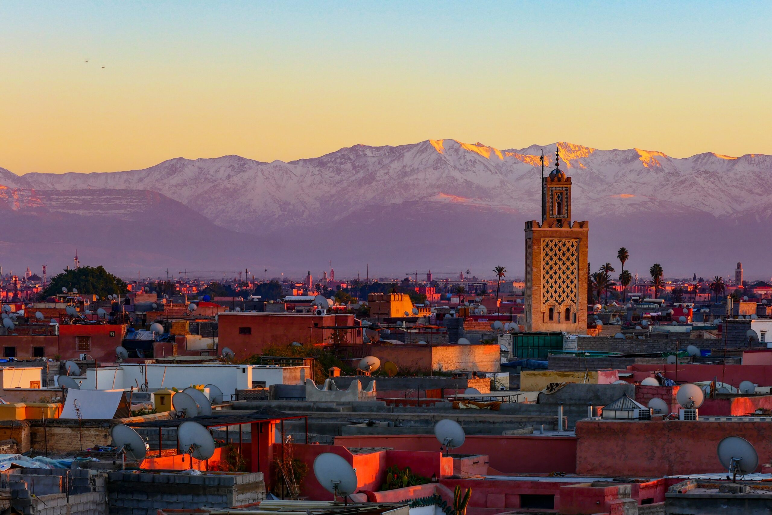 A sunset view of a skyline with mountains behind