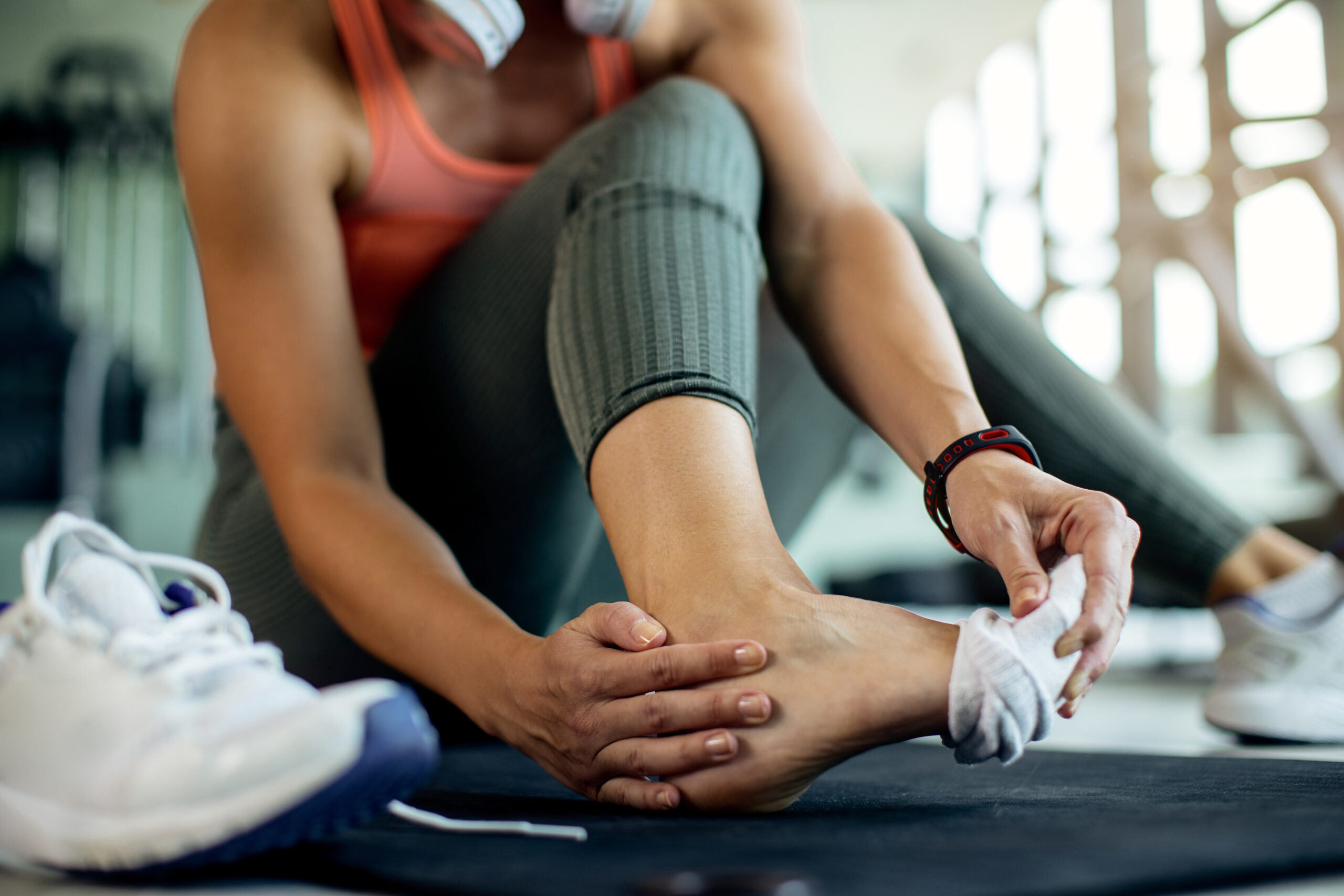 Woman with a sore ankle at the gym