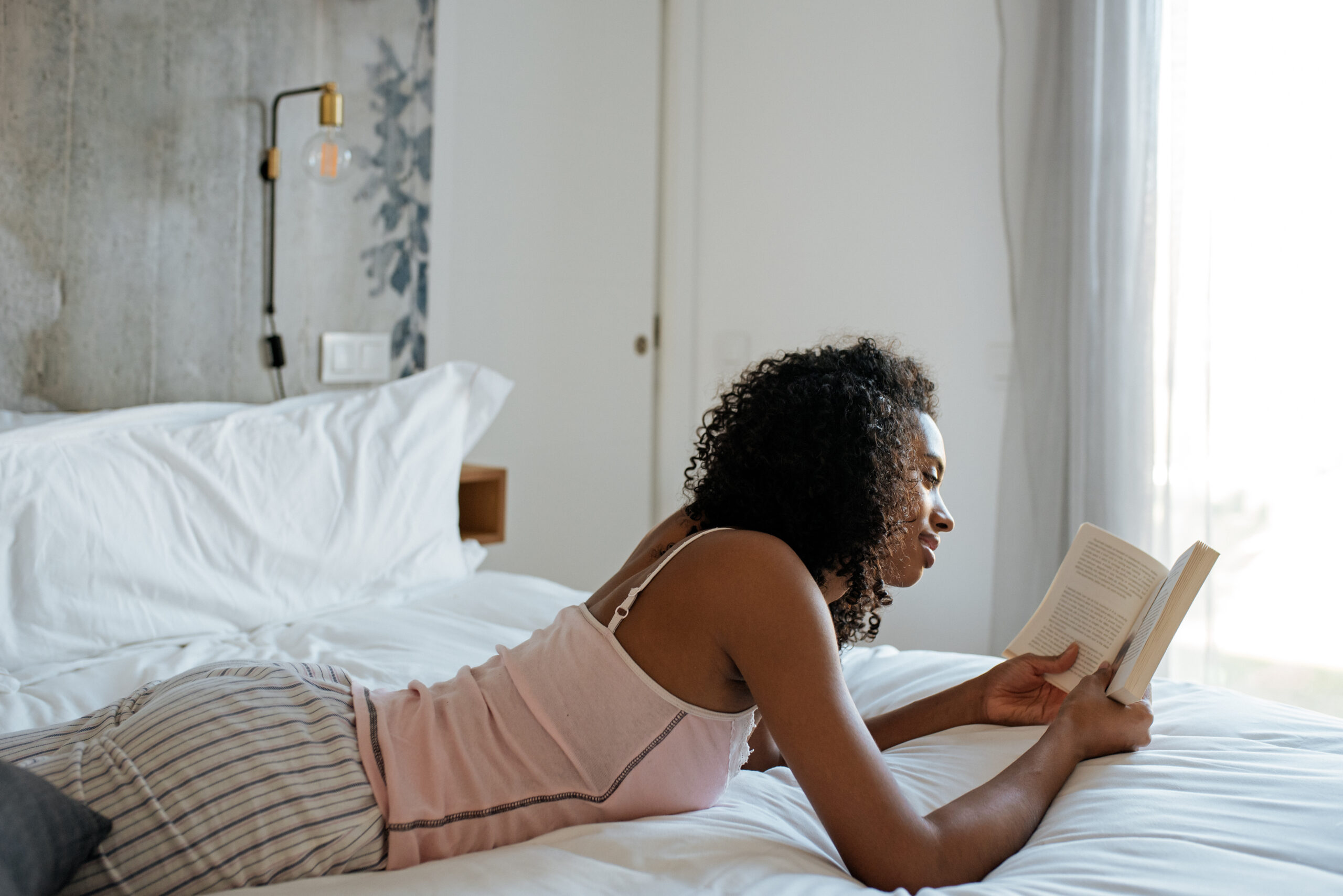 Woman reads on her bed