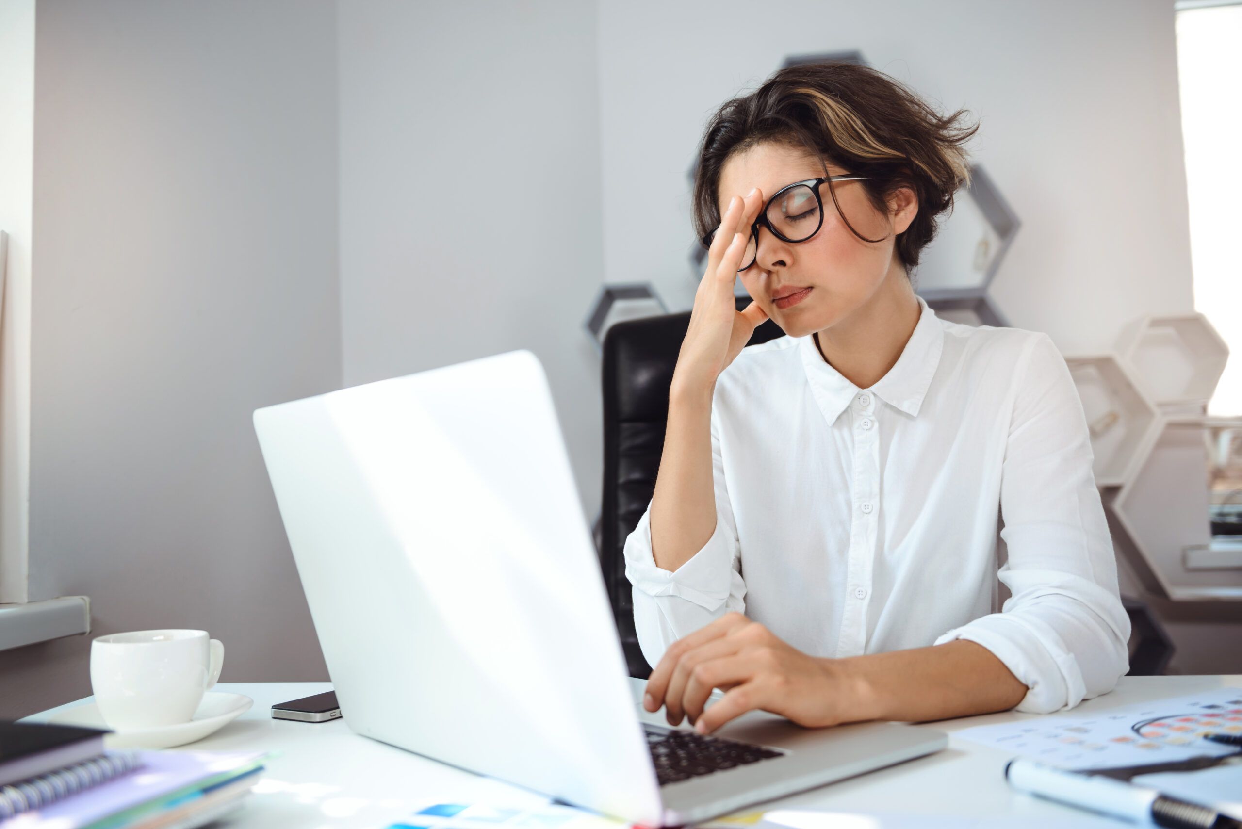 Woman with a headache at work