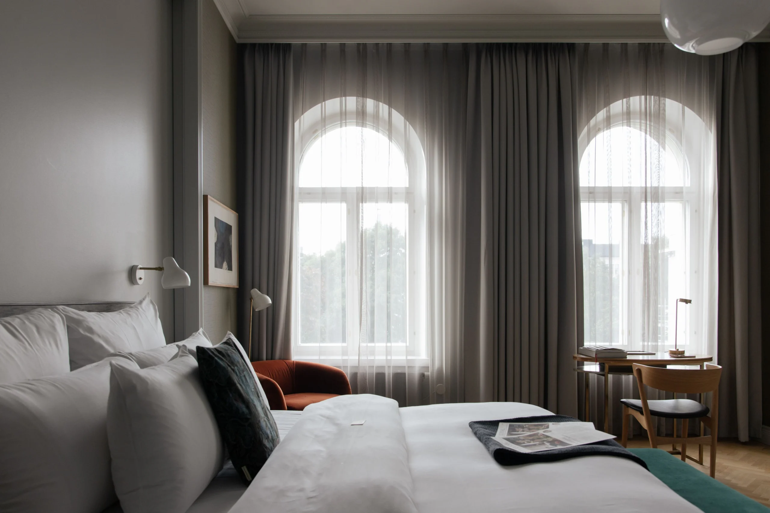 Light hotel room with white bed, curtains 