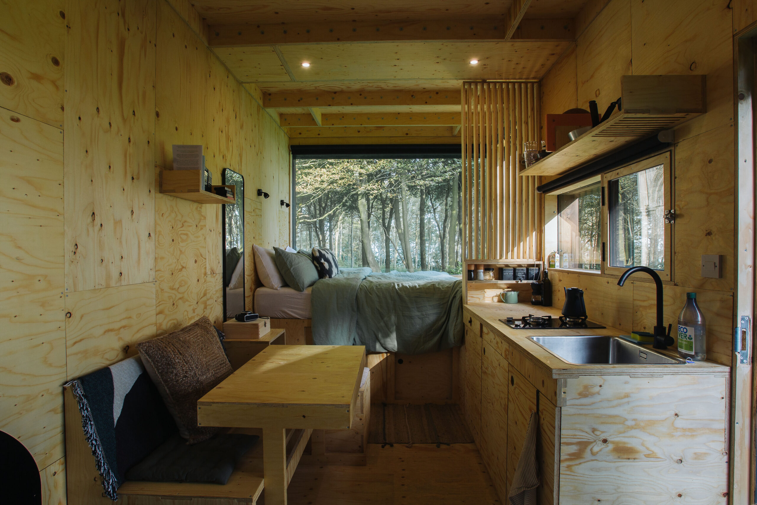Inside of an off grid cabin looking out to forest