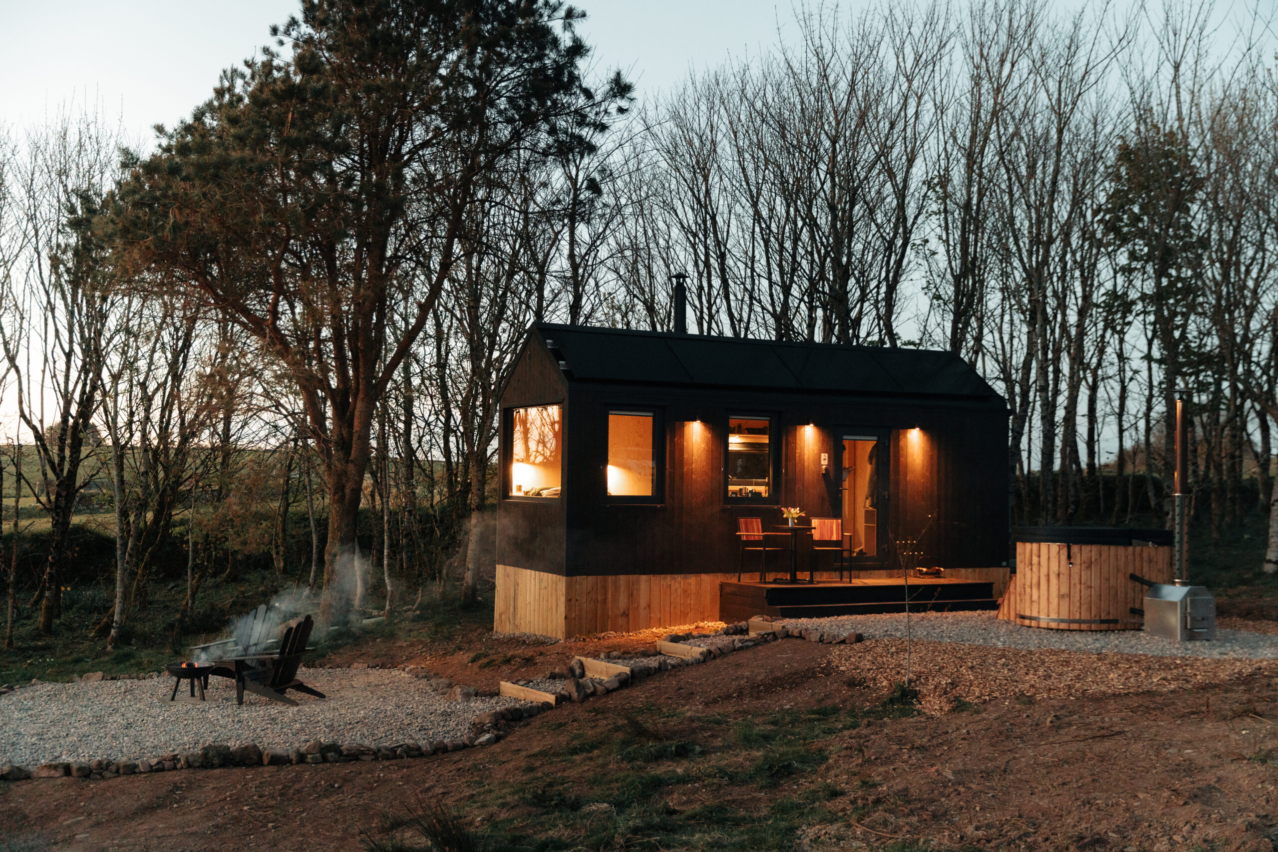 cabin in the woods at night time with a hot tub