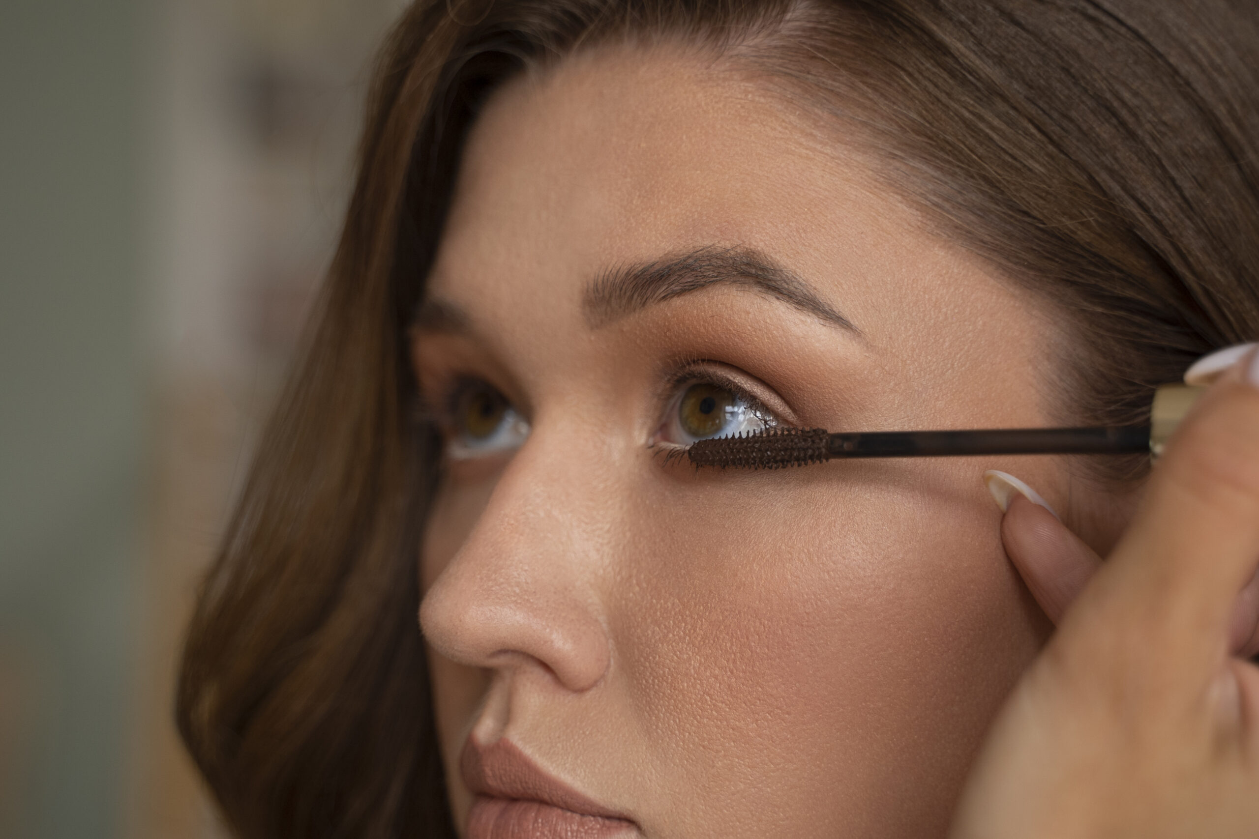 Woman applies brown mascara
