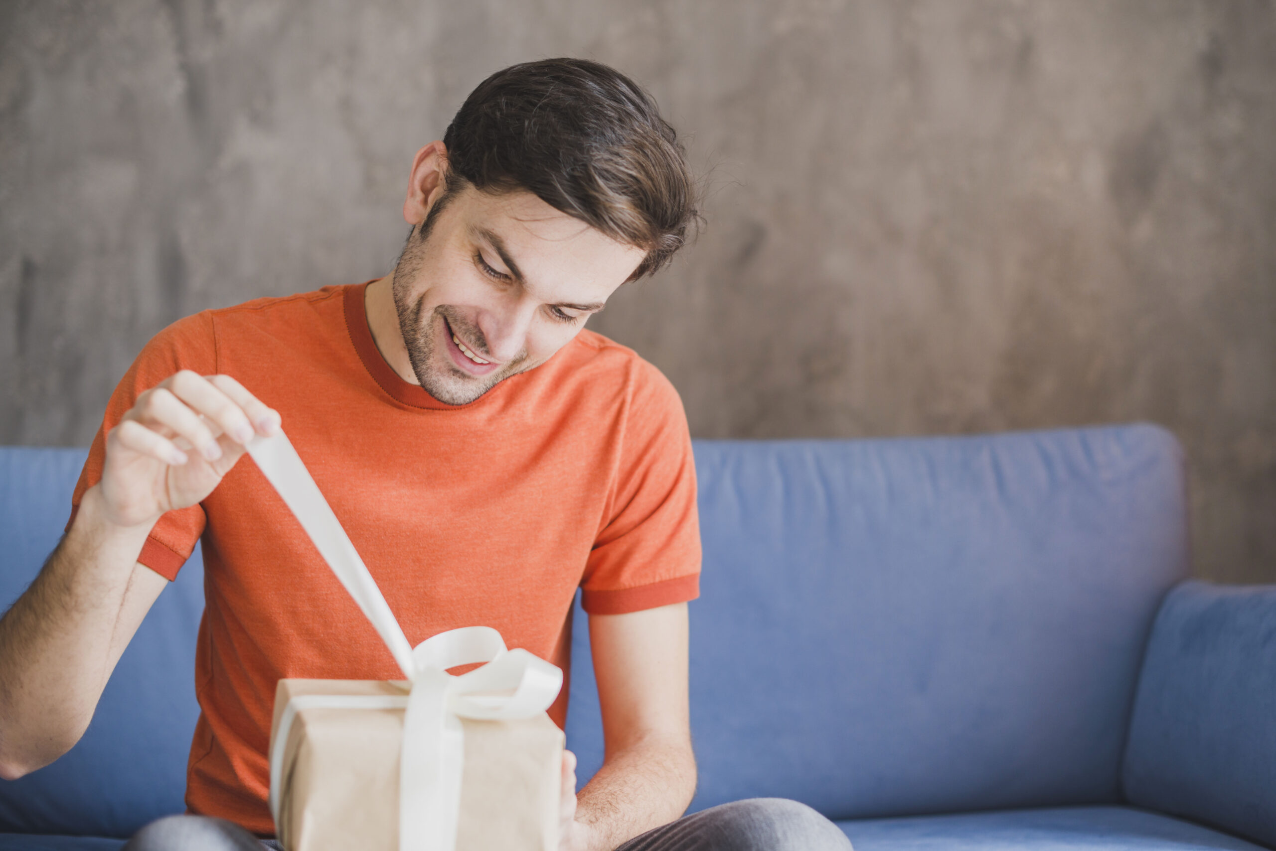 Man smiles as he opens a present