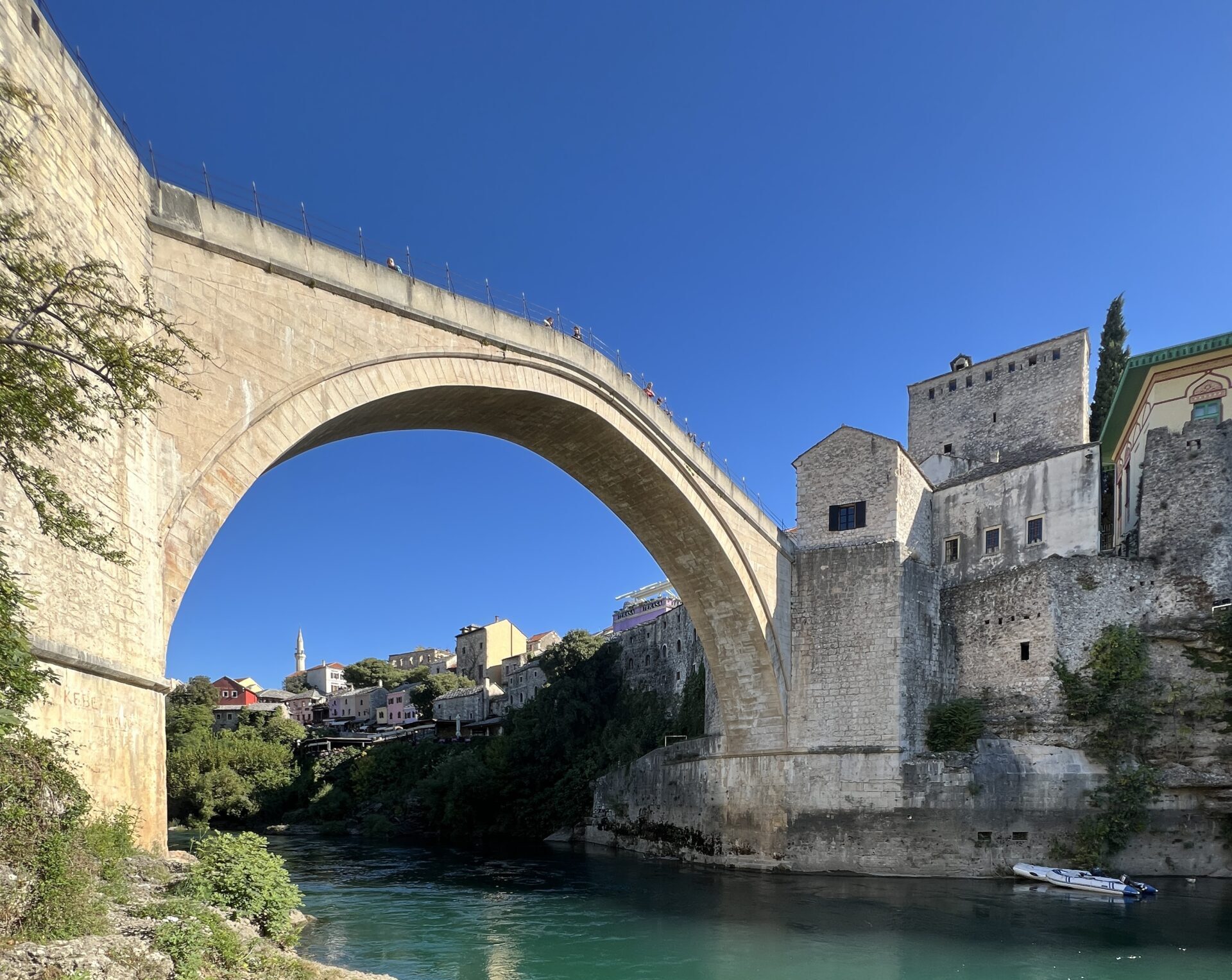 stone bridge connecting stone buildings from a village over a river