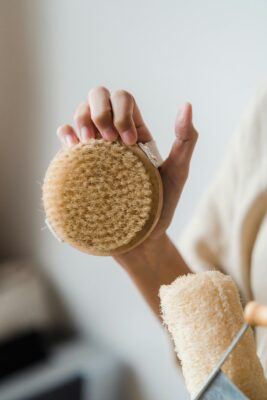 Someone holding a dry brush and a natural loofah