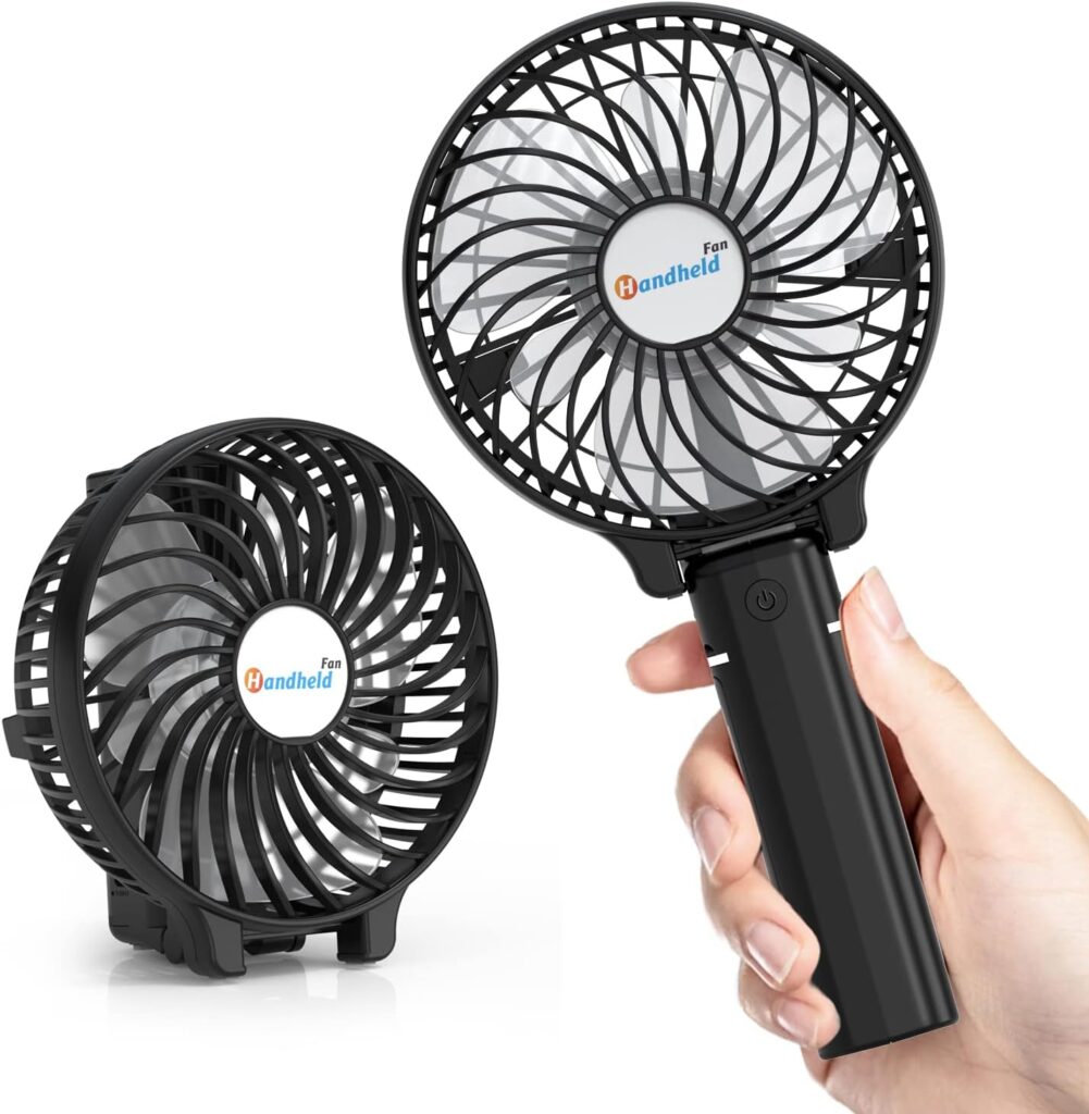 Hand reaching out from the right holding black handheld fan with handheld fan orange and blue logo in middle and on the left the same fan folded down to sit on the table