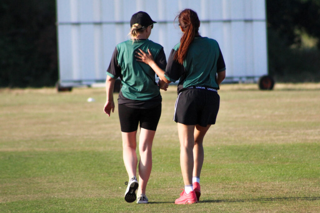 Two women training as a part of their local cricket team. 