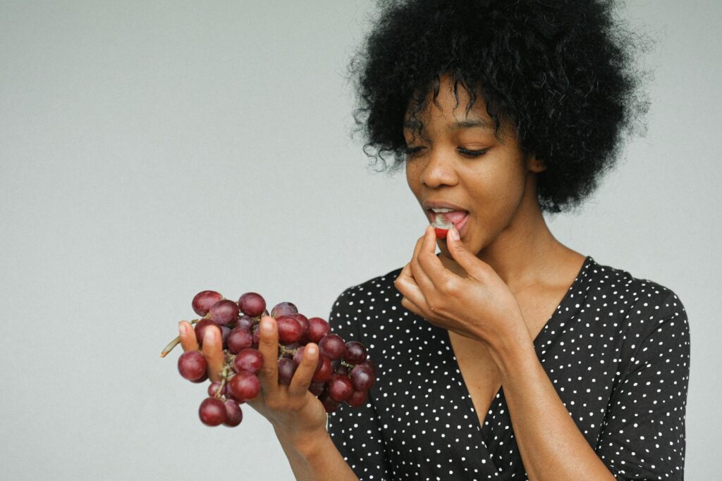 A woman eating grapes 