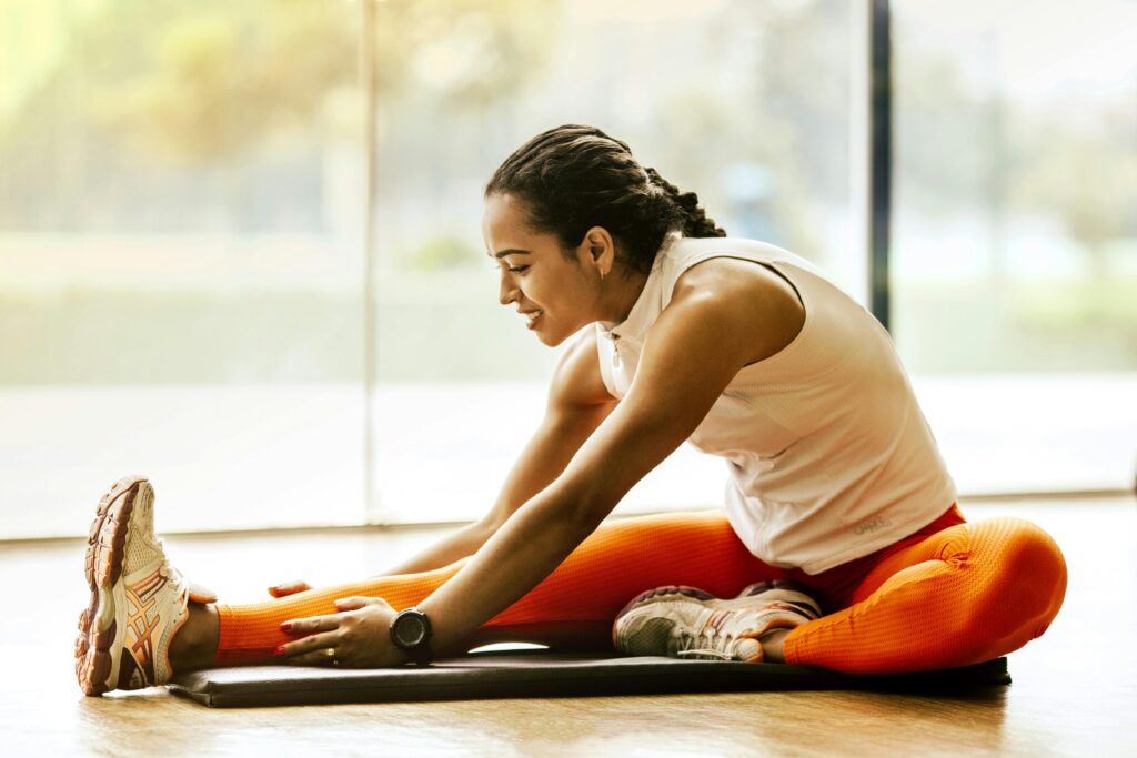 Woman stretching in the gym on a yoga mat 