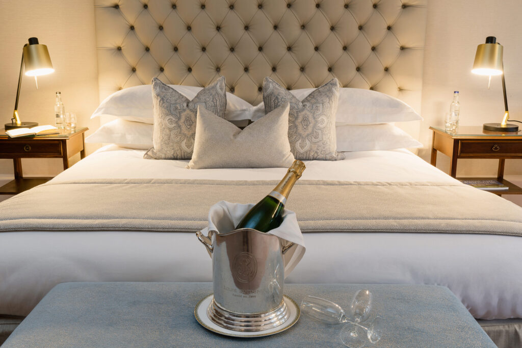 A champagne bottle on top of a bed at Ashdown Hotel