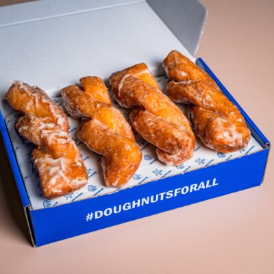 A bright blue box with four long twisted doughnuts