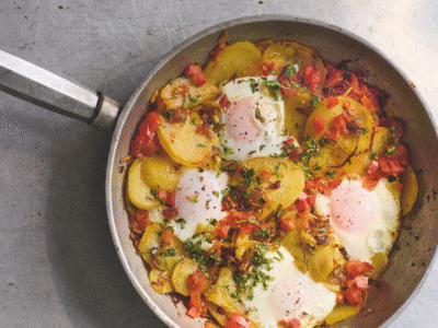Cooked eggs and potato dish in a steel frying pan