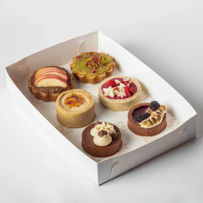 A box of six round pastry-based bakes in a white box