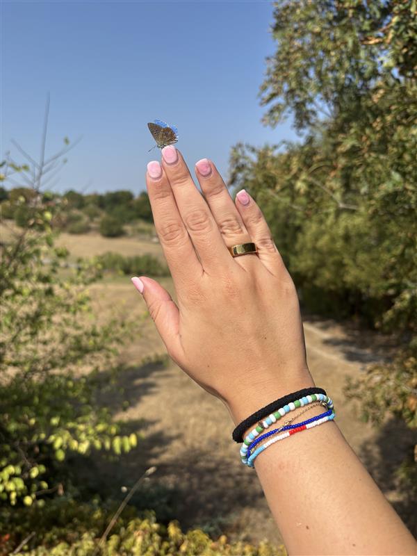 Evelyn wears the RingConn, while a butterfly lands on her hand