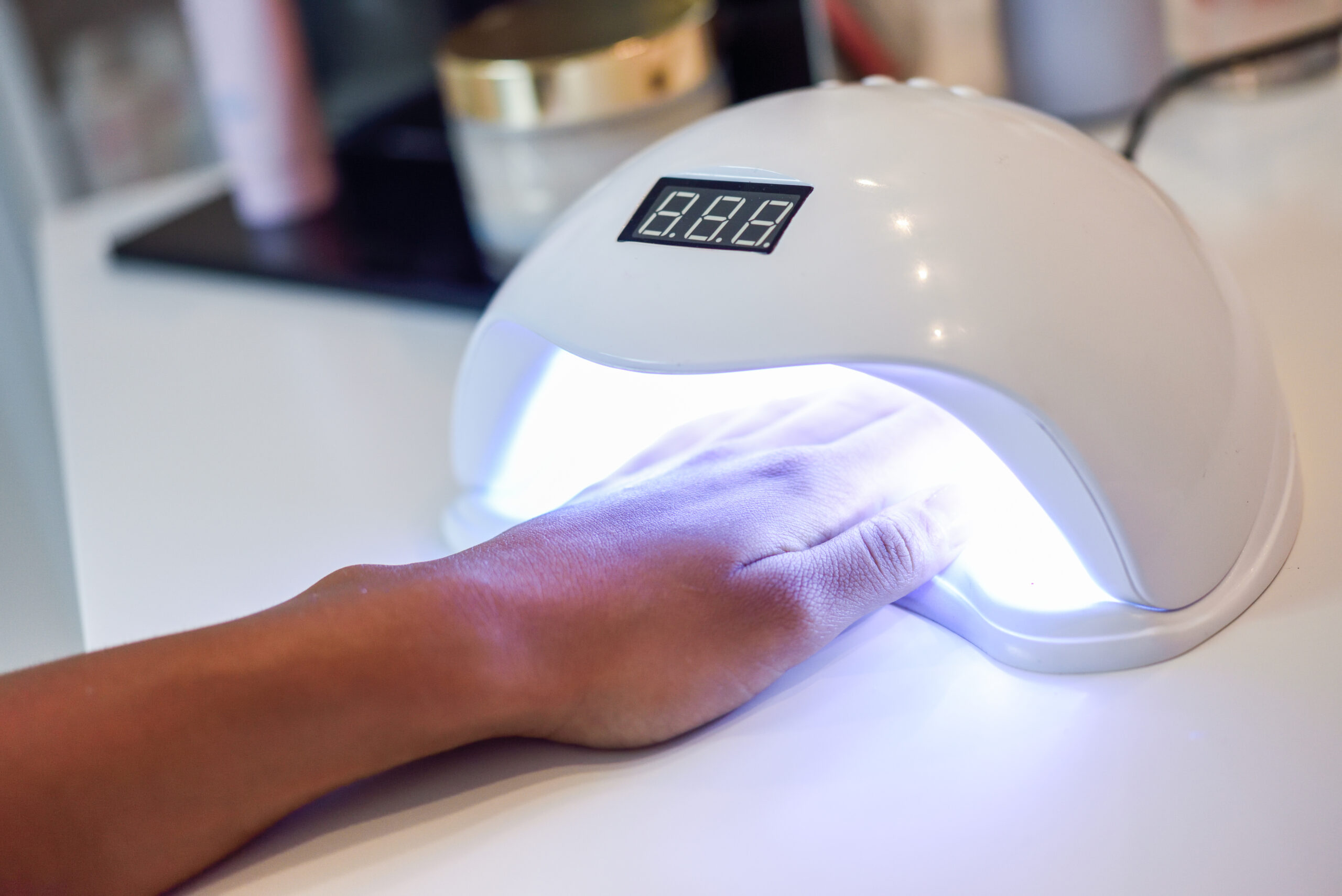 Manicured nails in UV lamp.