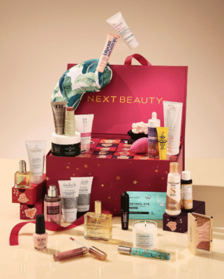 Next 25 Days of Beauty Advent Calendar fuchsia box with products coming out on beige background 