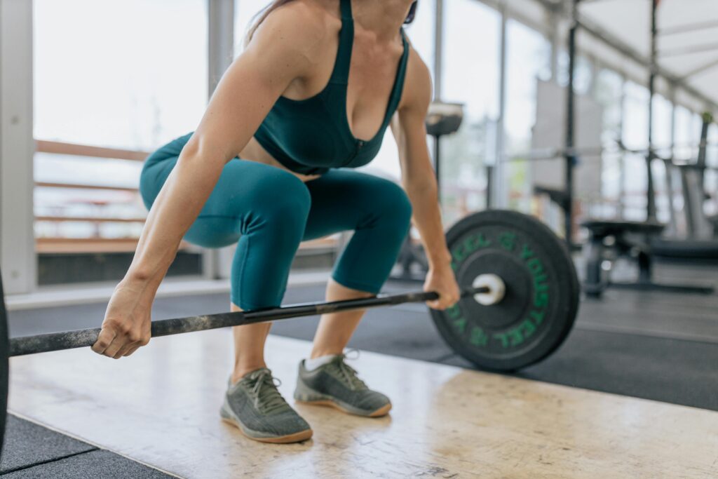A woman exercising with a barbell at the gym
