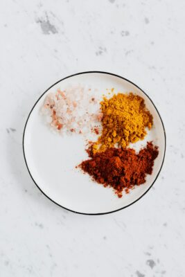 Three spices on a white plate on marble table