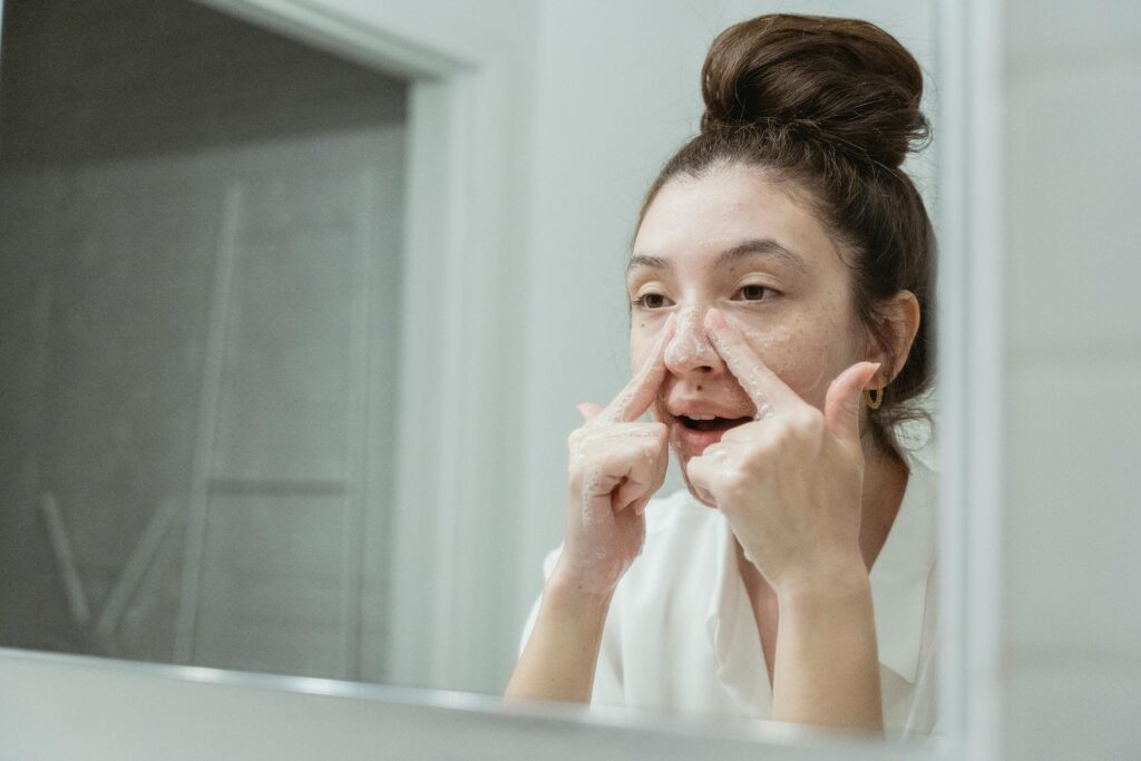 Woman applying skincare in mirror 